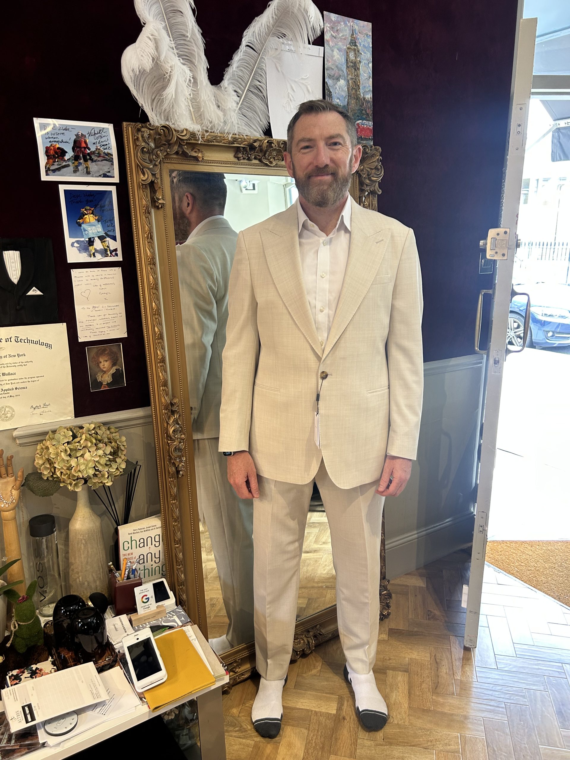 Man wearing a cream textured bespoke suit with peak lapels during a fitting in a London atelier