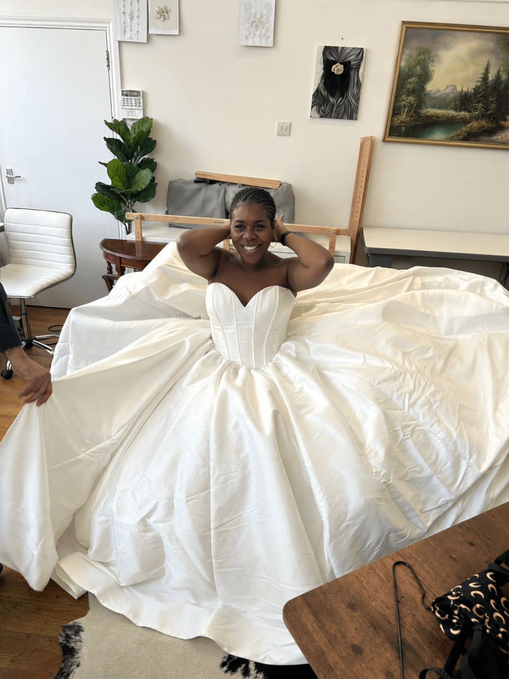 Bride smiling in a voluminous strapless white wedding gown during an atelier fitting